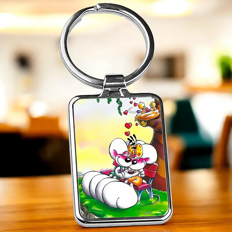 Porte-clé Diddl argenté rectangulaire avec illustration cartoon colorée de deux personnages sur un banc entourés de cœurs et vignes