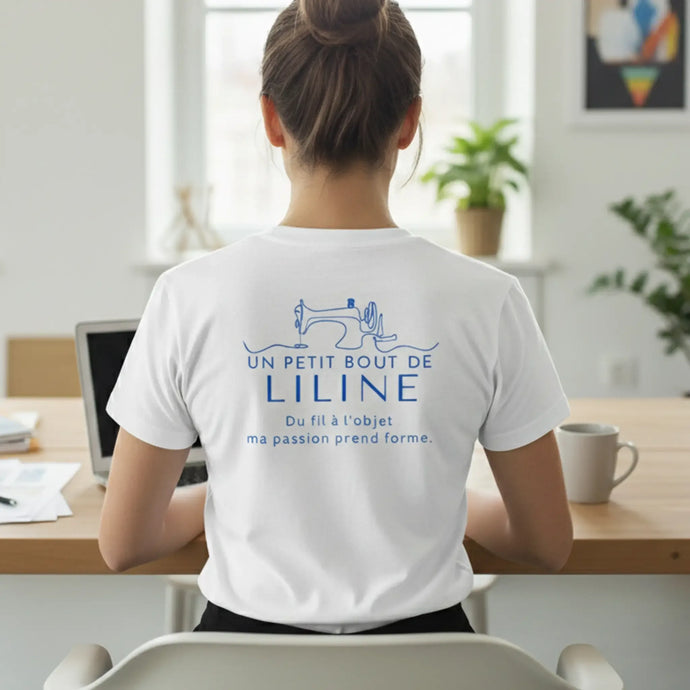 T-shirt en coton blanc avec une illustration en ligne bleue d'une machine à coudre et du texte ’un petit bout de liline’ en dessous